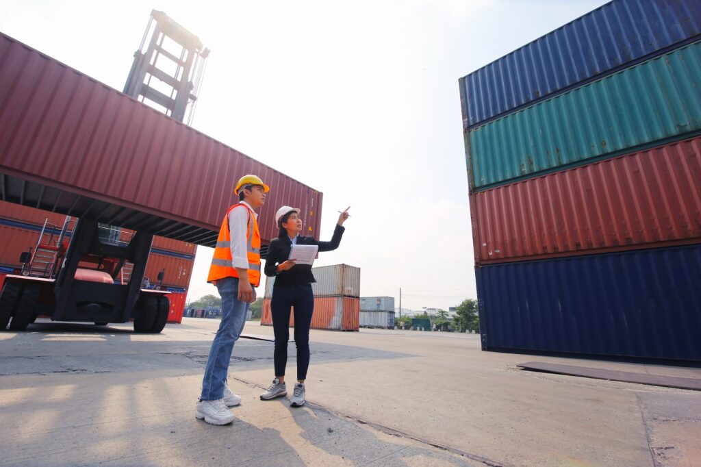 Foreman inspecting containers at import-export cargo area.