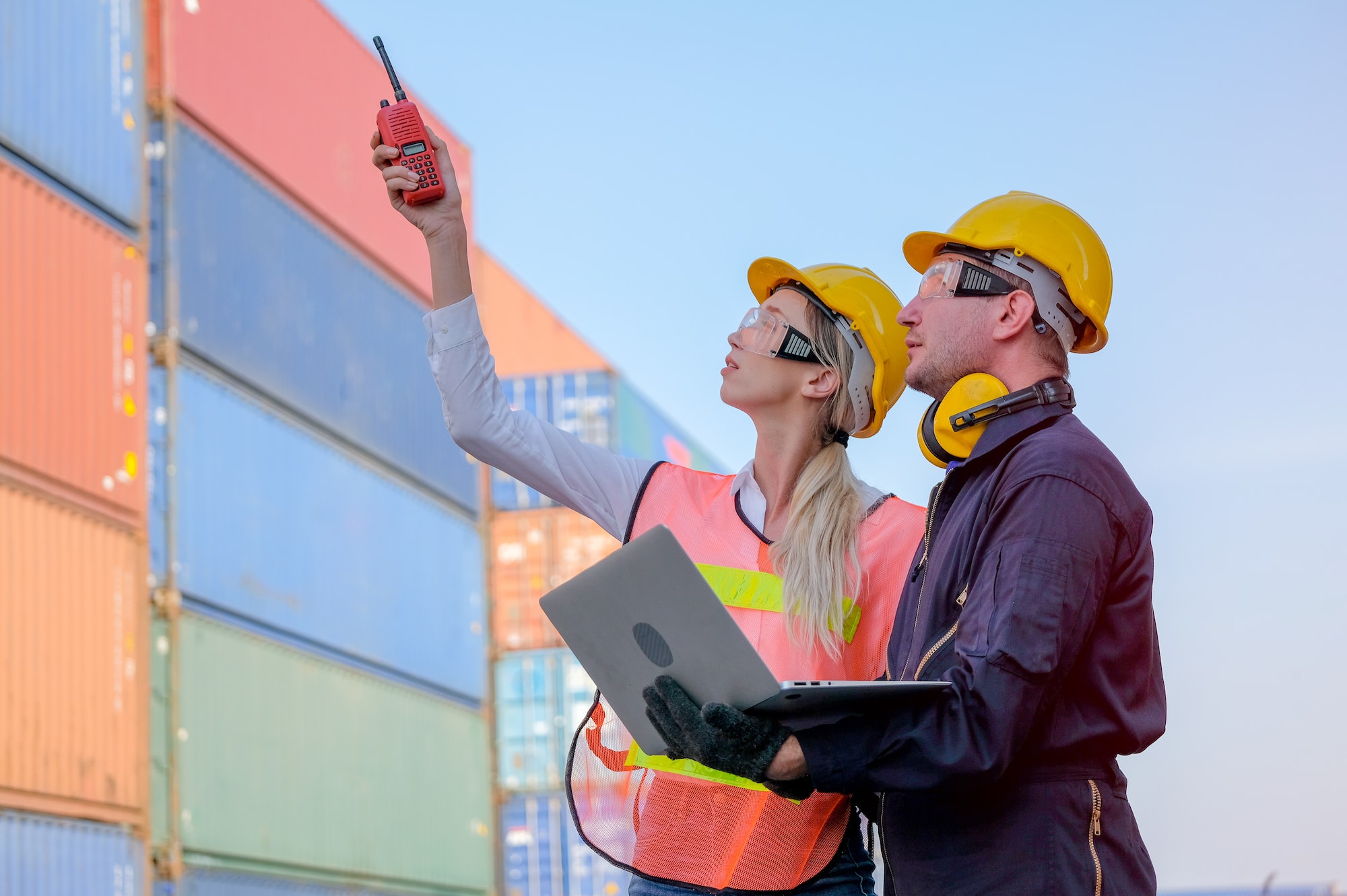 Worker woman use walkie-talkie point to some directions and discuss with technician